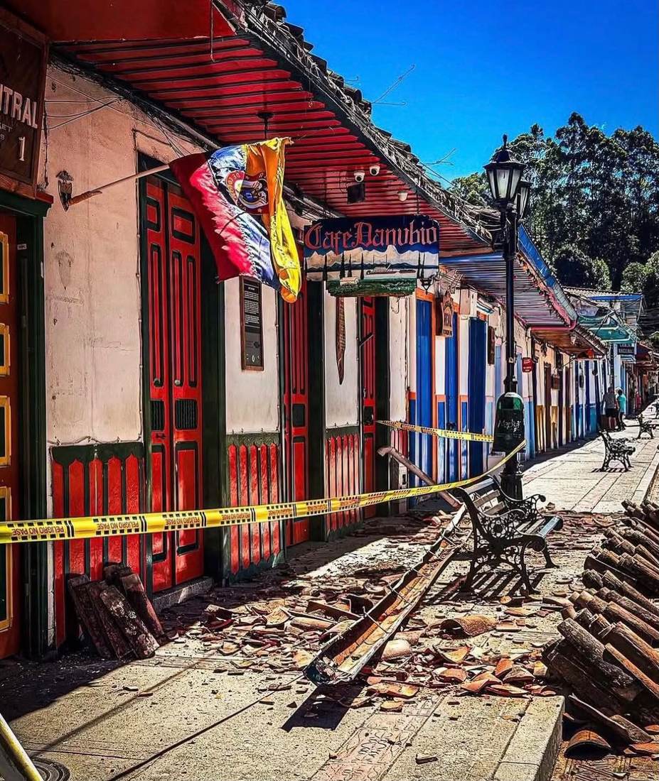 Calle de Salento acordonada con cinta, escombros de teja y banderines sobre la vía