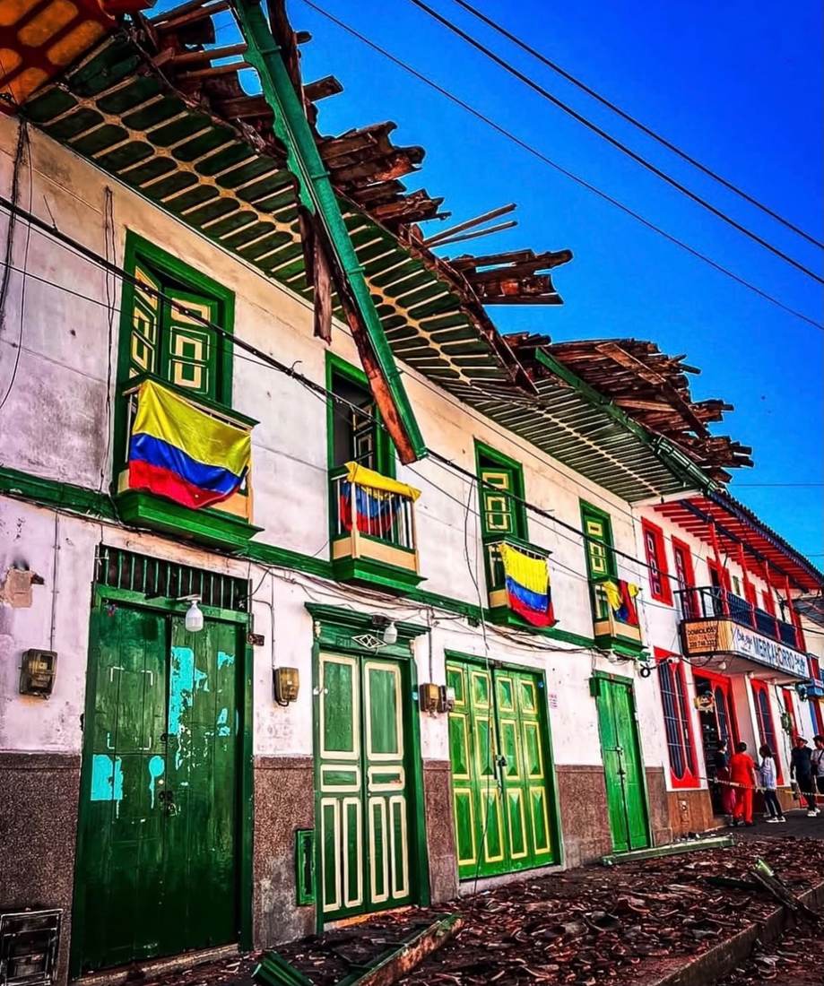 Fachadas de colores en Salento con la bandera de Colombia y un poste inclinado